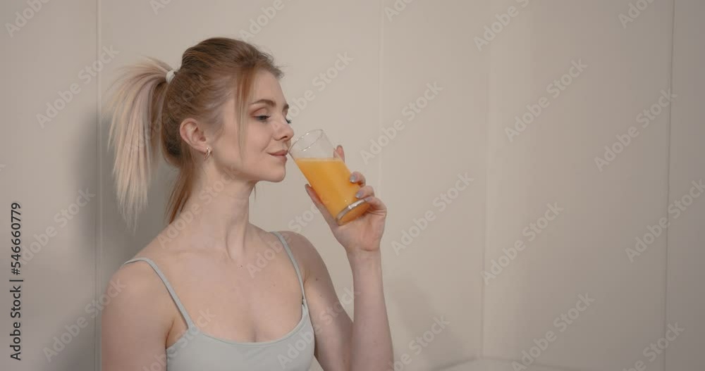Smiling woman drinking orange juice after sports training Smiling woman drinking orange juice after sports training