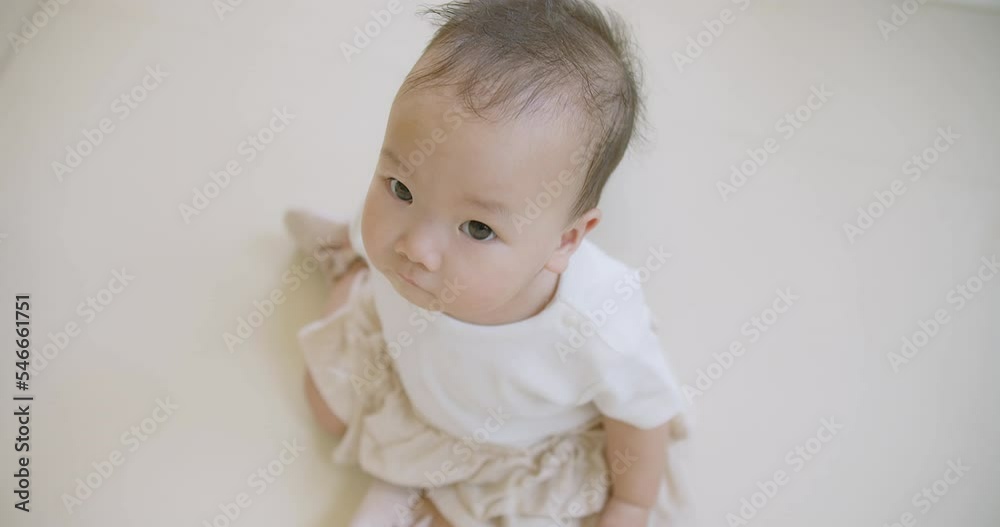 Portrait Top view of cute innocence adorable Asian baby toddler child looking at camera with curiosity in the room at home Portrait Top view of cute innocence adorable Asian baby toddler child looking at camera with curiosity in the room at home