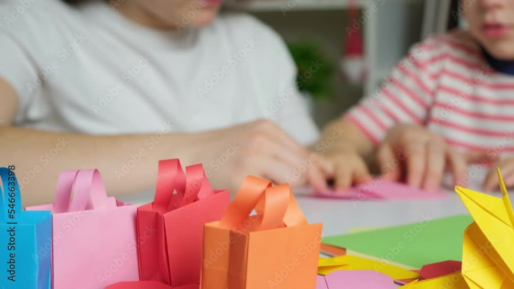 Mother and son make crafts from paper, origami, create animal figurines. Mother and son make crafts from paper, origami, create animal figurines.