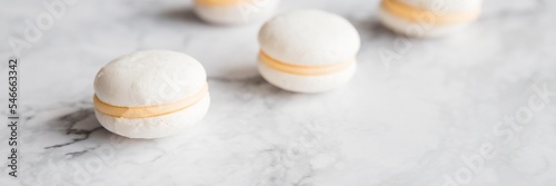 Cake macaron or macaroon on marble background from above, white almond cookies, pastel colors, vintage card, top view.advertisement, copy space. web banner