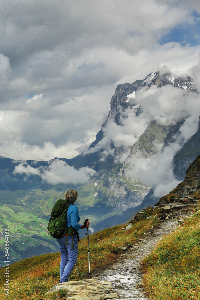 Lone woman hiking the Eiger trail in the Swiss Alps mountains
