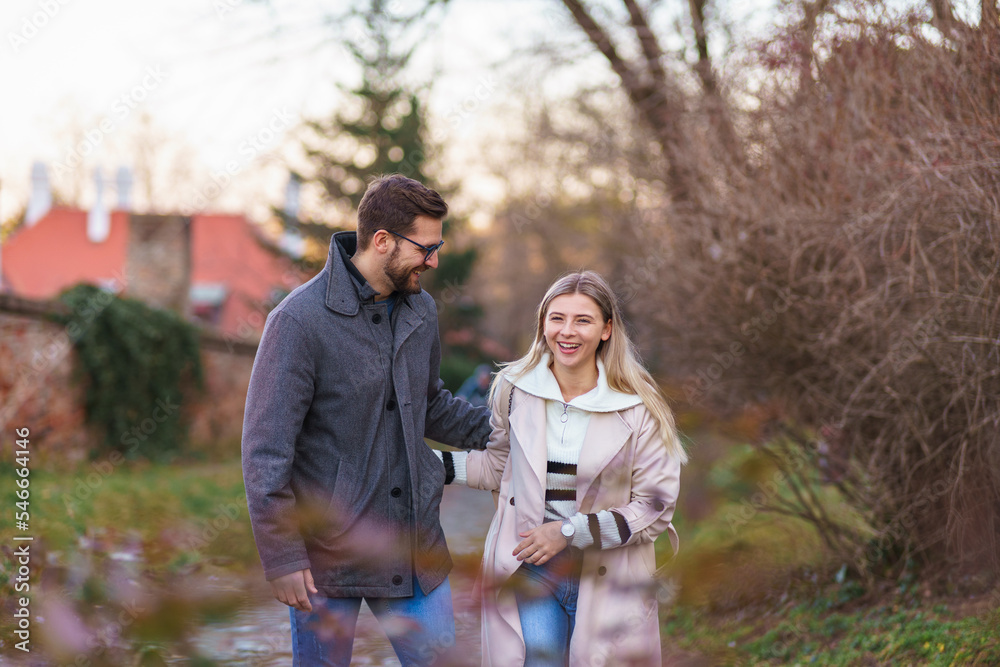 A portrait of a happy romantic couple walking outdoors in the surroundings of an old fortress