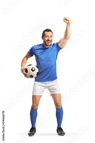 Excited fotball player holding a ball and cheering