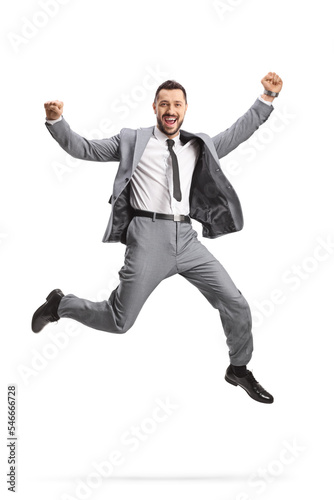 Excited young businessman in a grey suit jumping