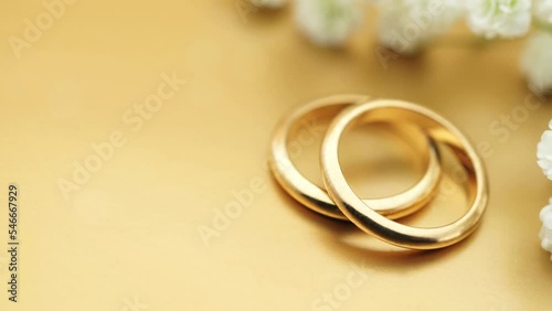 Gold wedding background with rings and soft light effects copy space for wedding invitation photo animation
