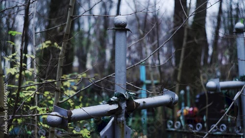 Religious cross in cemetery. Spooky cemetery landscape with old tombstones