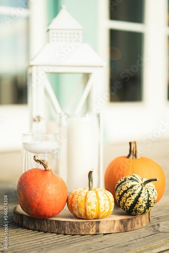 Closeup view of pumpkins with candles on a wooden stand on the table