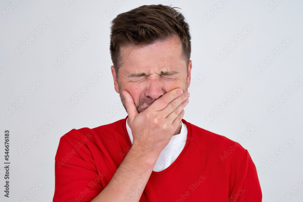  bored yawning tired caucasian man covering mouth with hand.