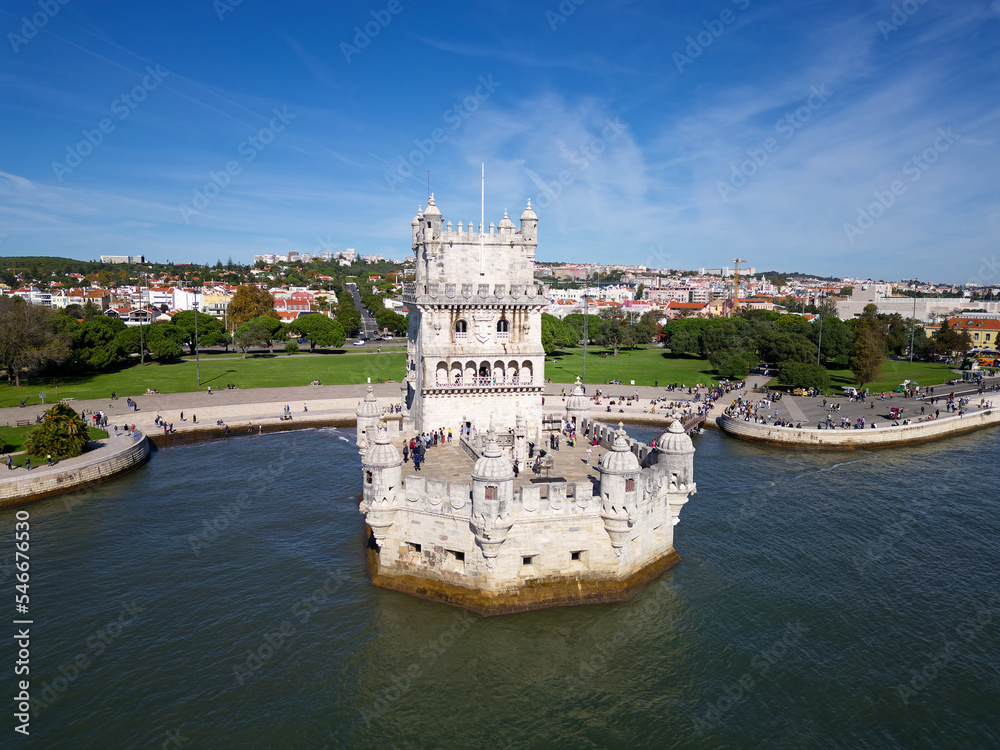 Aerial drone view of Belem Tower in Lisbon, Portugal during a beautiful sunny day next to the river Tagus. Unesco World Heritage. Historic visits. Holidays and summer vacation tourism. Colorful palace