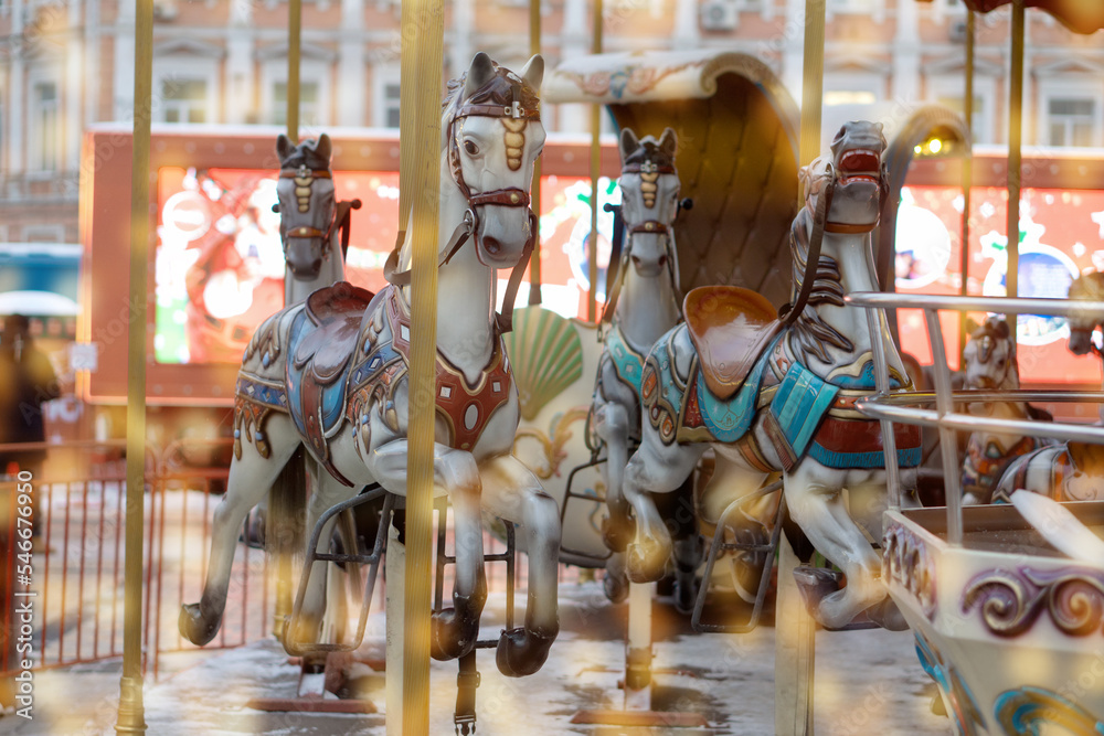 Traditional fair carousel with horses. An old French carousel in a leisure park in diffuse yellow lights.
