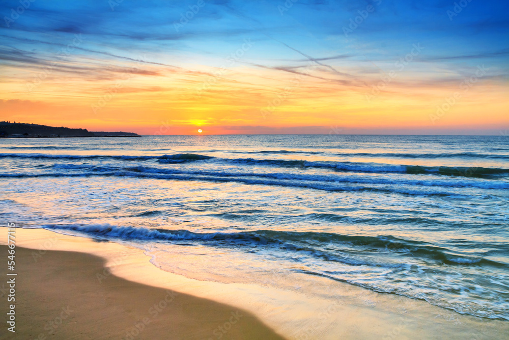 Seaside landscape - the beach with views of the sunrise over the sea, near the city of Varna, on the Black Sea coast of Bulgaria