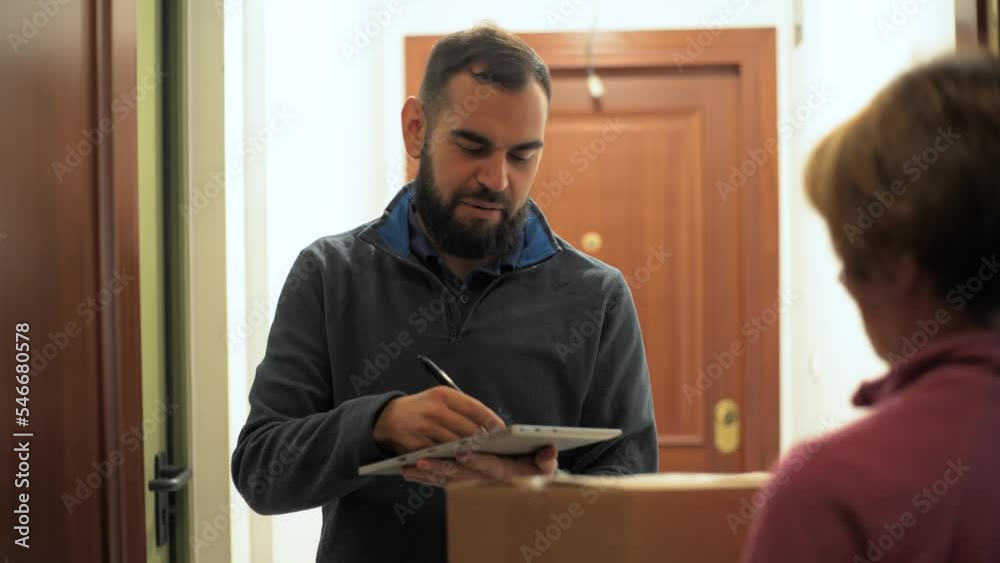 Bearded man delivering a package. Holding a parcel in front of the door. Bearded man delivering a package. Holding a parcel in front of the door.