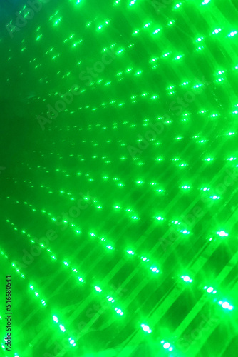 A wall of bright green lights lined up. Abstract background.