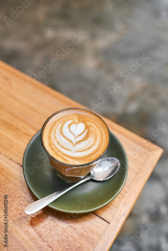 Latte on a green saucer with latte art