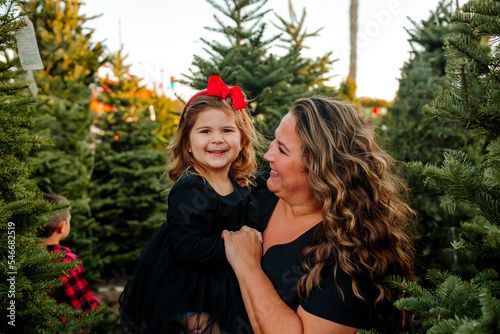 Happy Mother and daughter in front of pine trees  photo