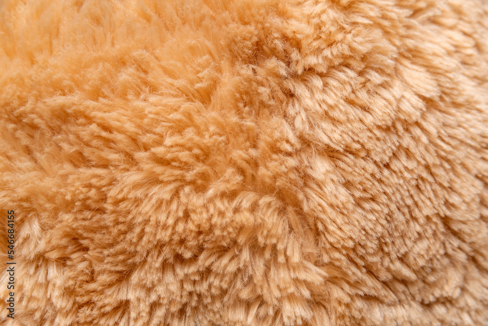 Close-up crumpled faux fur in peach or beige hue. Structure of fur fabric as background. Top view Close-up crumpled faux fur in peach or beige hue. Structure of fur fabric as background. Top view