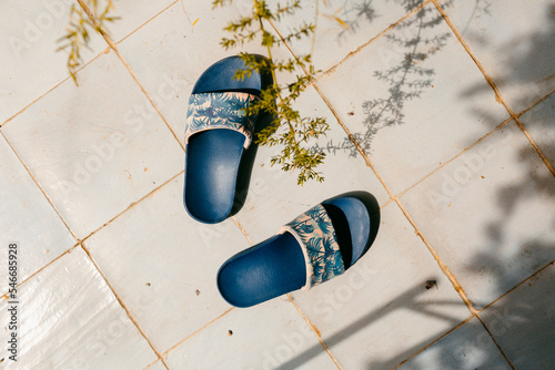  flip-flops on tile floor in sunlight