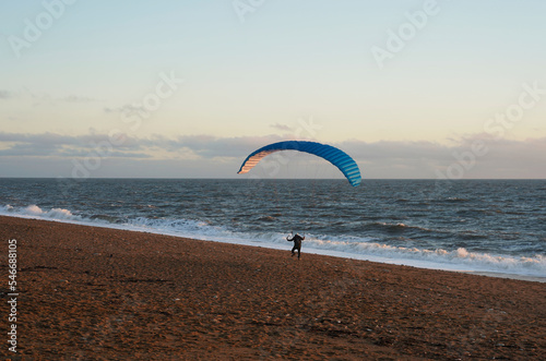 Paraglider walking on the beach, Dorset