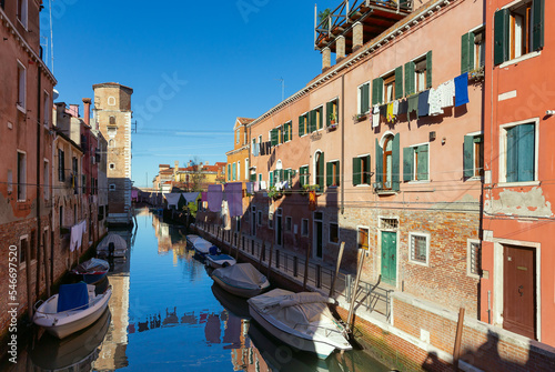 Traditional Venetian houses along the canal on a sunny day. © pillerss