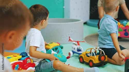 little boys playing with cars, trains and planes in the nursery, fun time. High quality 4k footage photo