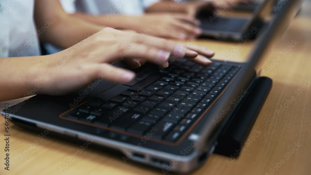 A school kid's fingers typing on a laptop. A school kid's fingers typing on a laptop.