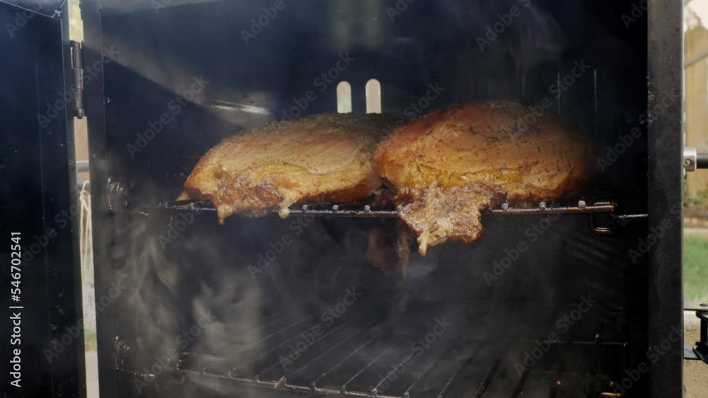 Turkey breasts smoking outside on a smoker