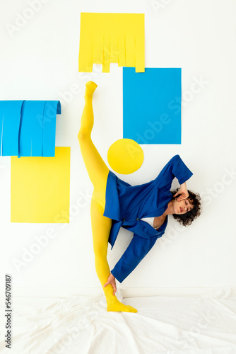 Graceful young lady doing split against wall at home photo