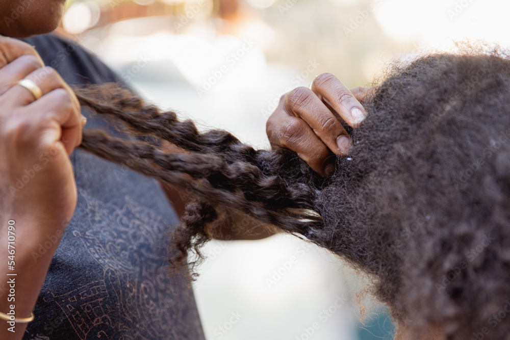 Mother combing her child's kinky curly coily hair Mother combing her child's kinky curly coily hair