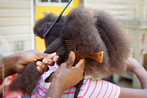 Mother combing her child's kinky curly coily hair