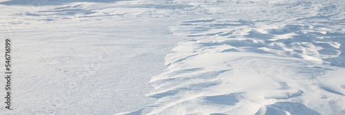 Snow texture. Wind sculpted patterns on snow surface. Wind in the tundra and in the mountains on the surface of the snow sculpts patterns and ridges. Arctic, Polar region. Winter panoramic background.