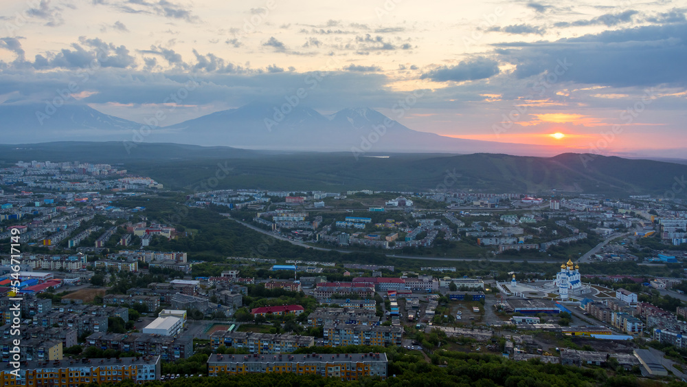 Morning cityscape. Top view of the cathedral, buildings and streets. Residential urban areas at sunrise. Volcanoes in the distance. City of Petropavlovsk-Kamchatsky, Kamchatka Krai, Far East of Russia