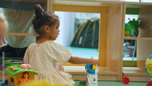 adorable preschoolers enjoying in the playroom with their beautiful teacher. High quality 4k footage photo