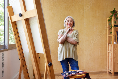 Cheerful senior artist in home studio photo