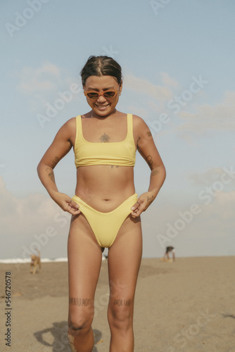 Asian girl in bikini at the beach standing.
