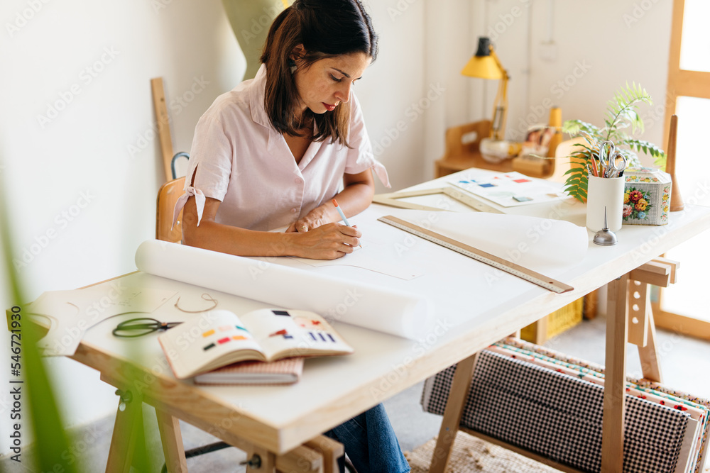 a dressmaker working on her patterns. a dressmaker working on her patterns.
