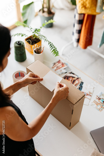 a woman places a label on a package 