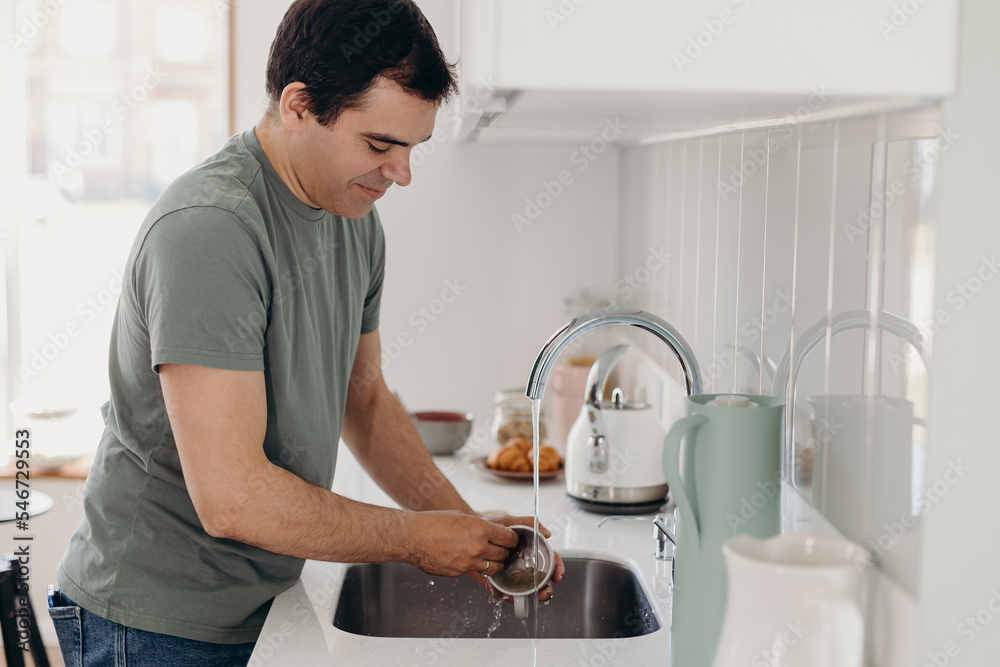 Mature Hispanic man washing cup Mature Hispanic man washing cup