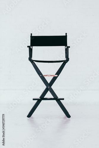Black director's chair in a bright and airy white brick warehouse