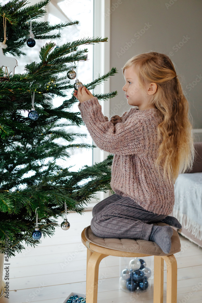 © Sergey Narevskih/Stocksy - Child decorating Christmas tree © Sergey Narevskih/Stocksy - Child decorating Christmas tree
