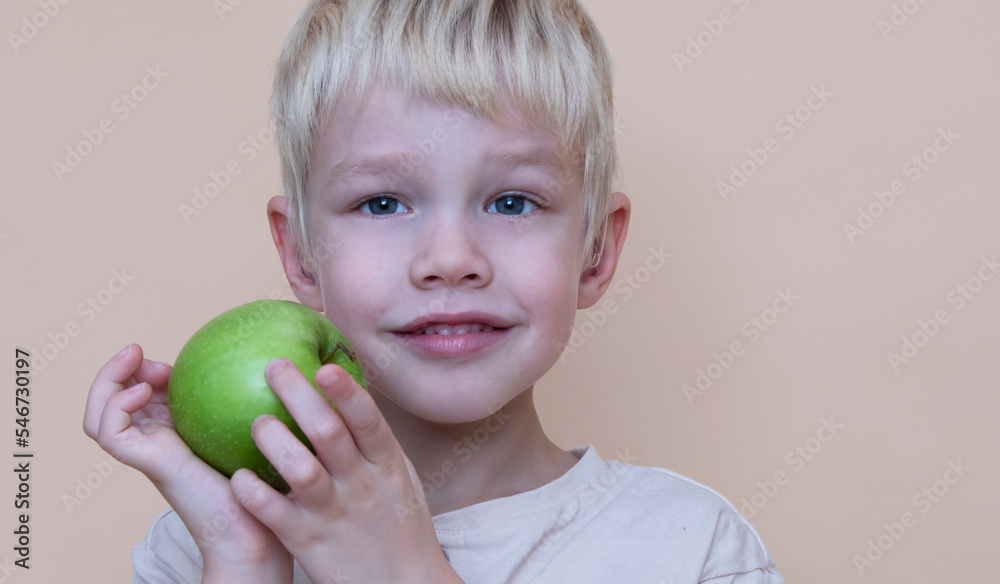 small boy holds a big green apple, healthy food and vitamins, smiling, white background, soft focus small boy holds a big green apple, healthy food and vitamins, smiling, white background, soft focus