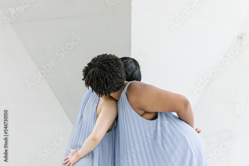 Two dancers leaning on each other  photo