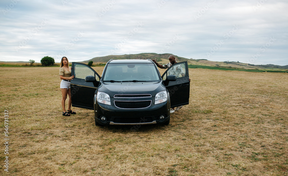 Black couple standing near car Black couple standing near car