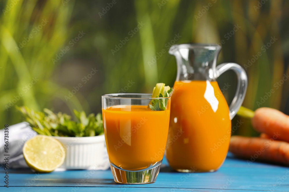 Tasty carrot juice on blue wooden table outdoors Tasty carrot juice on blue wooden table outdoors