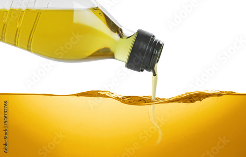 Pouring cooking oil from bottle against white background