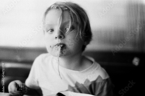 a blond boy eating pasta  photo