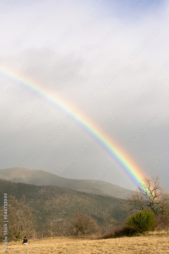 unrecognizable woman running towards a rainbow unrecognizable woman running towards a rainbow