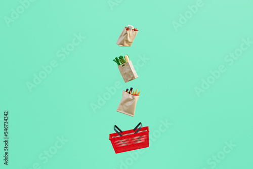 Paper bags filled with groceries floating over shopping basket photo