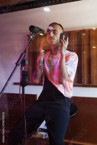 Young hipster rapper recording songs in music recordi photo