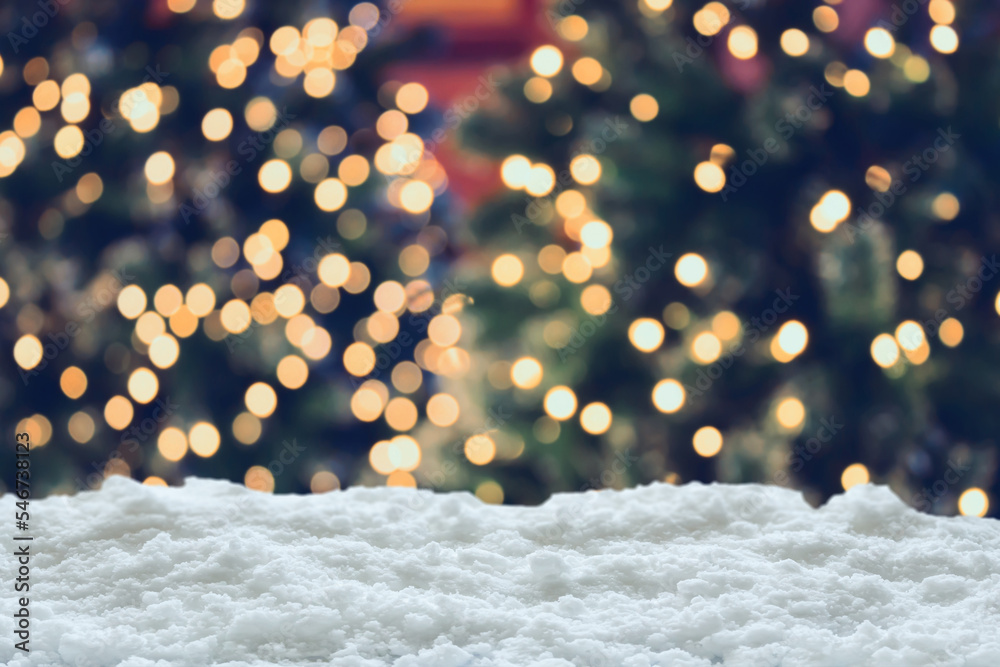 Fototapeta premium Empty white snow with blur Christmas tree with bokeh light background