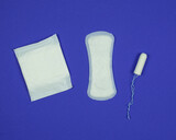 Hygiene products for women. Sanitary napkins and tampon on dark blue background